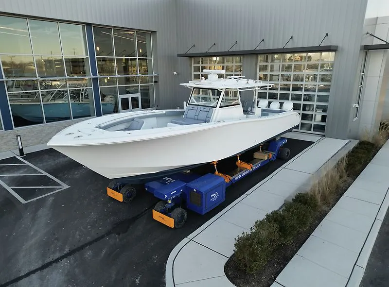Slide: The Image of 2022 Yellowfin 42 Offshore boat outside a modern building. - 2