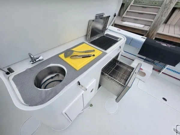 Slide: The Image of Yellowfin 42 Offshore 2022 kitchen area with sink and grill. - 20