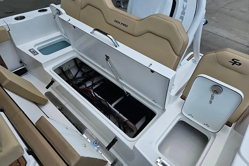 Slide: The Image of 2026 Sea Pro 225FLX Sandbar boat interior with open storage compartments and tan seating. - 12