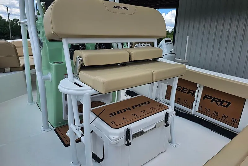 Slide: The Image of 2026 Sea Pro 225FLX Sandbar boat interior with tan seating and storage compartments. - 14
