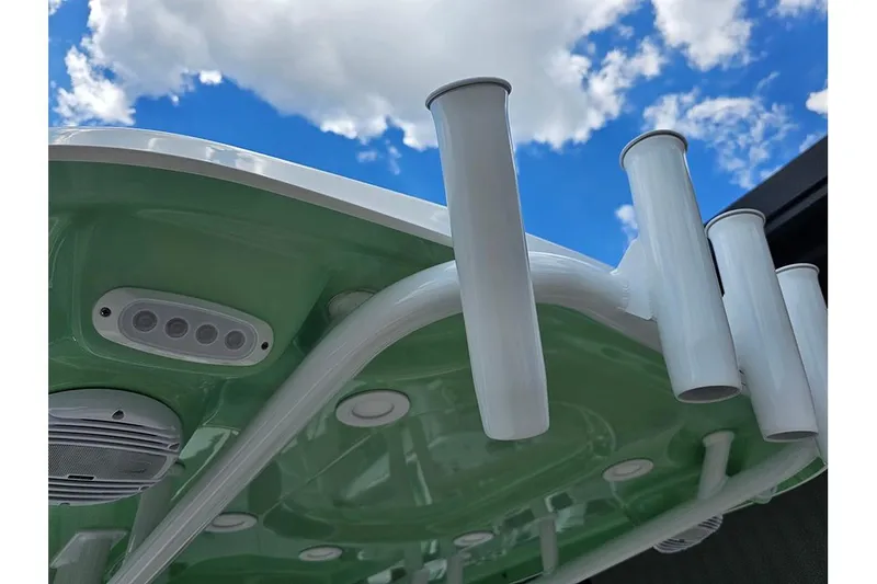 Slide: The Image of 2026 Sea Pro 225FLX Sandbar boat with rod holders and speakers against a blue sky. - 17