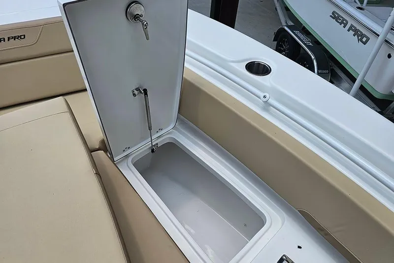Slide: The Image of Open storage compartment on 2026 Sea Pro 225FLX Sandbar boat, featuring beige seating. - 24