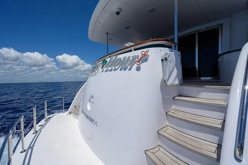 Slide: The Image of 2007 Hatteras 80 Motor Yacht on open sea, featuring elegant deck and stairs. - 13