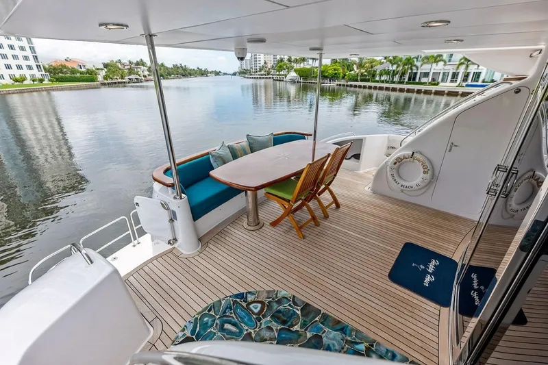 Slide: The Image of 2007 Hatteras 80 Motor Yacht deck with seating and scenic waterfront view. - 7