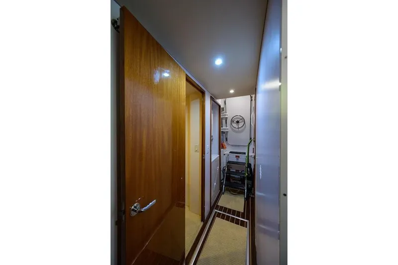 Slide: The Image of Hallway inside 2007 Hatteras 80 Motor Yacht, featuring wooden door and utility area. - 31