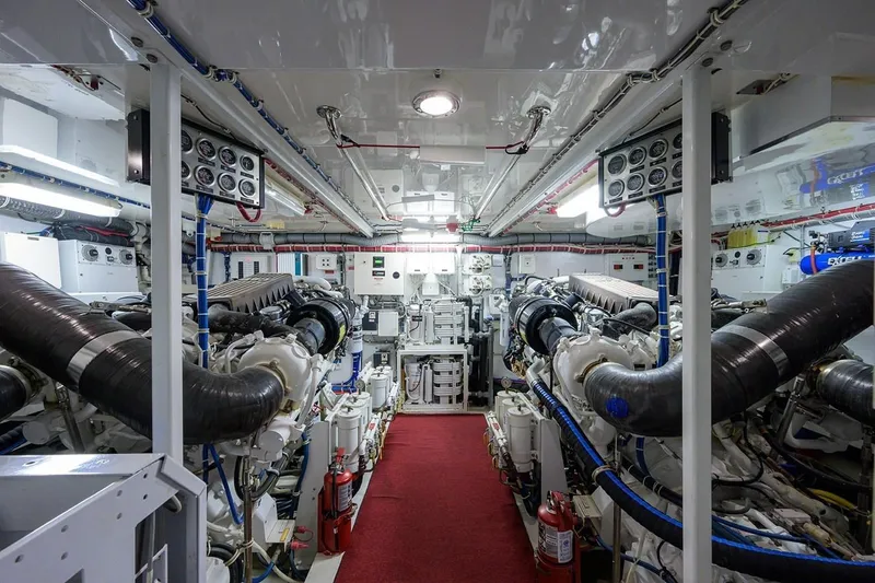 Slide: The Image of Engine room of a 2007 Hatteras 80 Motor Yacht, featuring dual engines and control panels. - 32