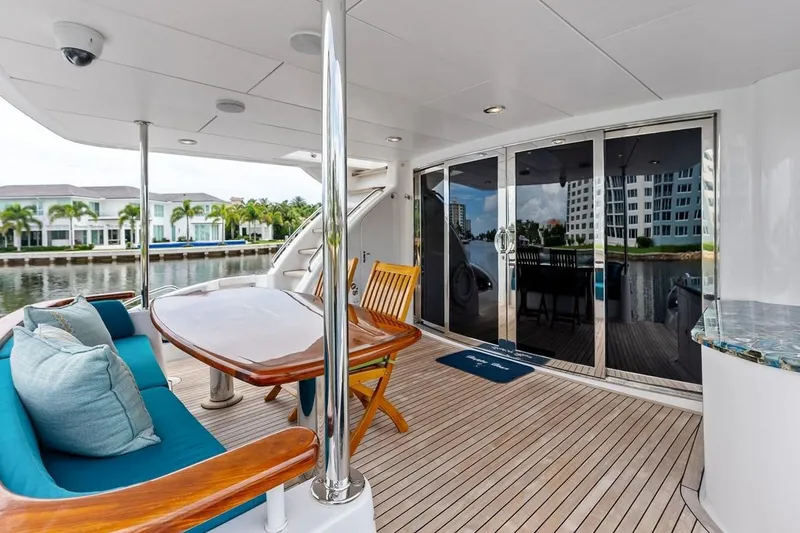 Slide: The Image of Luxurious 2007 Hatteras 80 Motor Yacht deck with elegant seating and waterfront view. - 5