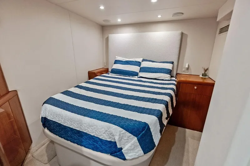 Slide: The Image of Luxurious bedroom in 2007 Hatteras 80 Motor Yacht with striped bedding and wooden accents. - 44