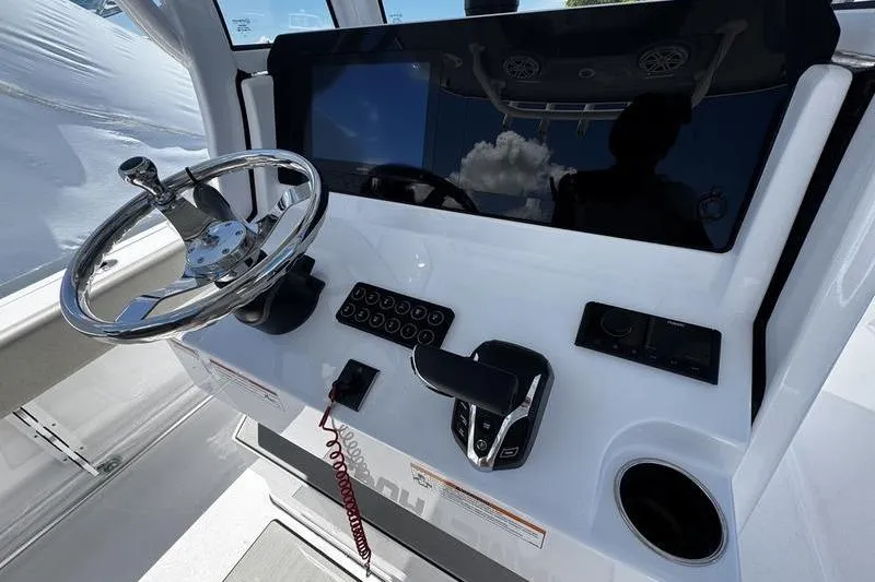 Slide: The Image of 2026 Sportsman Open 232 Center Console helm with steering wheel and control panel. - 23