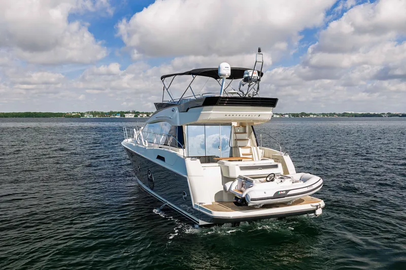 Slide: The Image of 2017 Monte Carlo Yachts MC5 cruising on open water under a partly cloudy sky. - 10