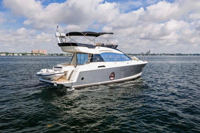 Slide: The Image of 2017 Monte Carlo Yachts MC5 cruising on open water under a partly cloudy sky. - 19