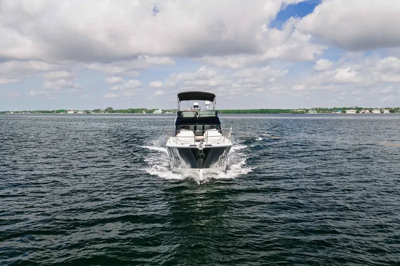 Slide: The Image of 2017 Monte Carlo Yachts MC5 cruising on open water under a partly cloudy sky. - 2