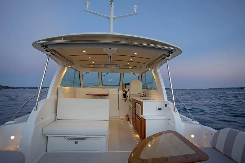Slide: The Image of Manufacturer Provided Image: 2026 Back Cove 34O boat interior with seating and kitchenette at sunset on the water. - 3