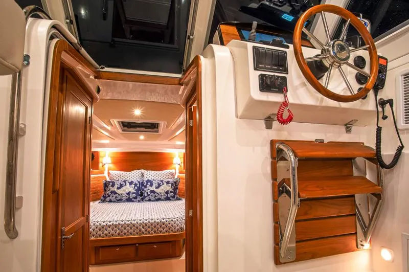 Slide: The Image of Manufacturer Provided Image: Interior of 2026 Back Cove 34O boat, featuring cozy cabin and wooden helm station. - 6