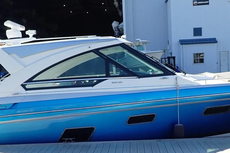 The Image of 2022 Formula 400 Super Sport Crossover boat docked near a building. - 1