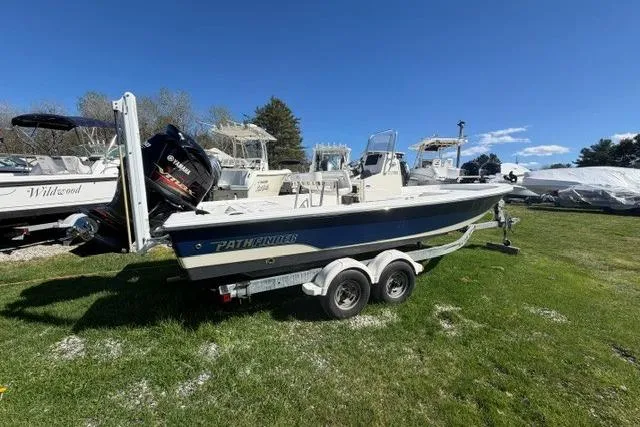 The Image of 2012 Pathfinder 2200 Tournament Edition boat on trailer, parked on grass under clear blue sky. - 1
