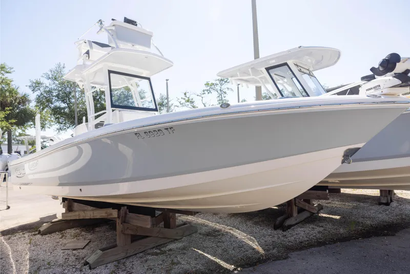 The Image of 2022 Robalo 246 Cayman SD boat displayed on wooden supports outdoors. - 0