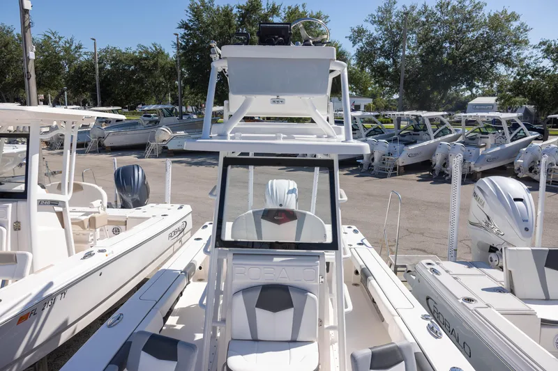 Slide: The Image of 2022 Robalo 246 Cayman SD boat displayed in a marina with multiple vessels. - 10