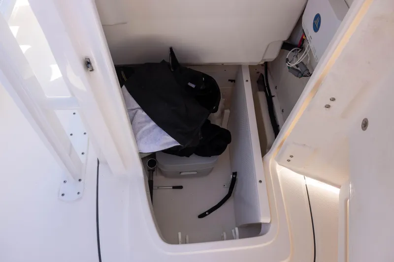 Slide: The Image of Storage compartment inside 2022 Robalo 246 Cayman SD boat, featuring organized equipment and gear. - 13