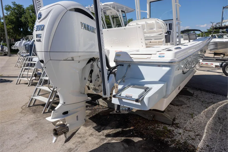 Slide: The Image of 2022 Robalo 246 Cayman SD boat with Yamaha V6 engine, displayed outdoors. - 2