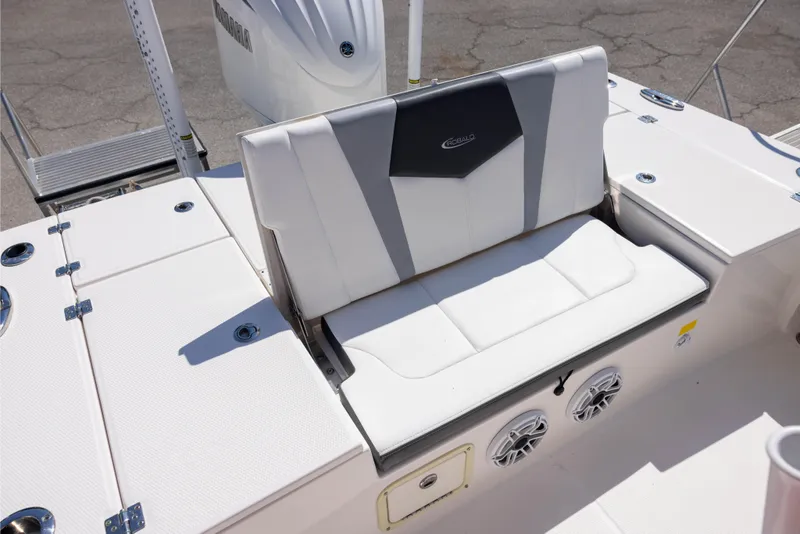 Slide: The Image of 2022 Robalo 246 Cayman SD boat seating area with white upholstery and integrated speakers. - 6