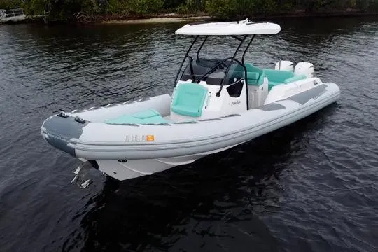 The Image of 2024 Ranieri Cayman 27.0 Sport boat on calm water, featuring sleek design and turquoise seating. - 1