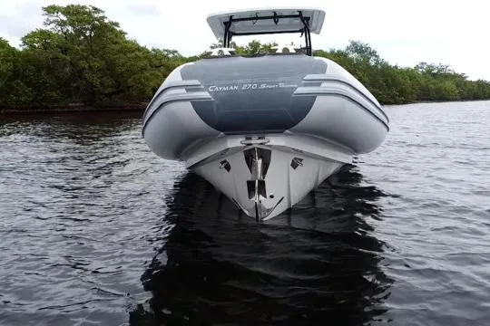 Slide: The Image of 2024 Ranieri Cayman 27.0 Sport boat on water, front view, surrounded by trees. - 10