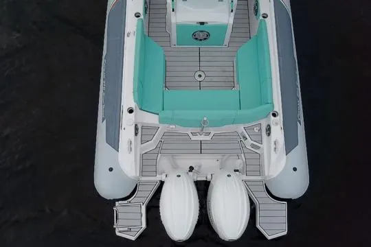 Slide: The Image of 2024 Ranieri Cayman 27.0 Sport boat, aerial view, featuring teal seating and dual engines. - 12