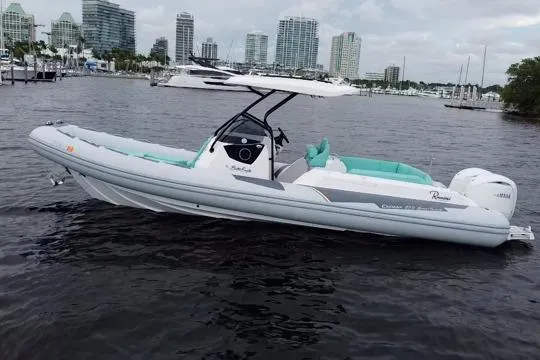 Slide: The Image of 2024 Ranieri Cayman 27.0 Sport boat on water, city skyline in background. - 4