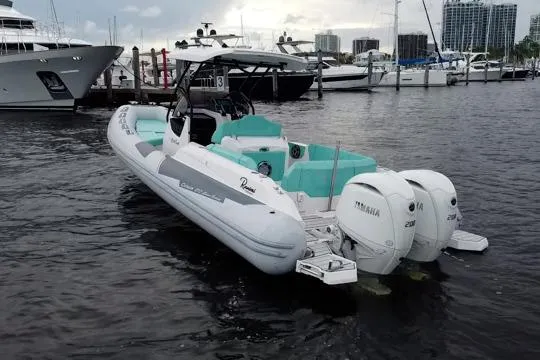 Slide: The Image of 2024 Ranieri Cayman 27.0 Sport boat docked, featuring twin Yamaha engines, in a marina setting. - 5