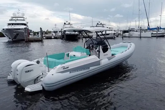 Slide: The Image of 2024 Ranieri Cayman 27.0 Sport boat docked, featuring Yamaha engines, in a marina setting. - 7