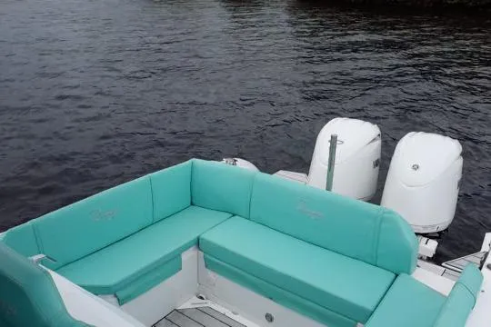 Slide: The Image of 2024 Ranieri Cayman 27.0 Sport boat with teal seating and dual outboard motors. - 9