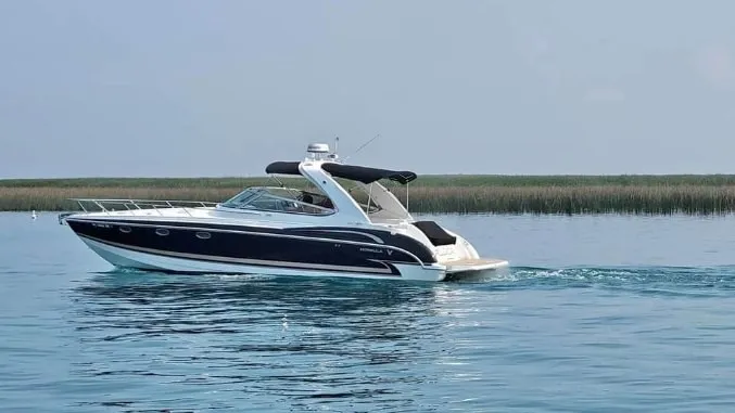 Slide: The Image of A 2005 Formula 370 Super Sport on calm water with a blue sky in the background. - 32