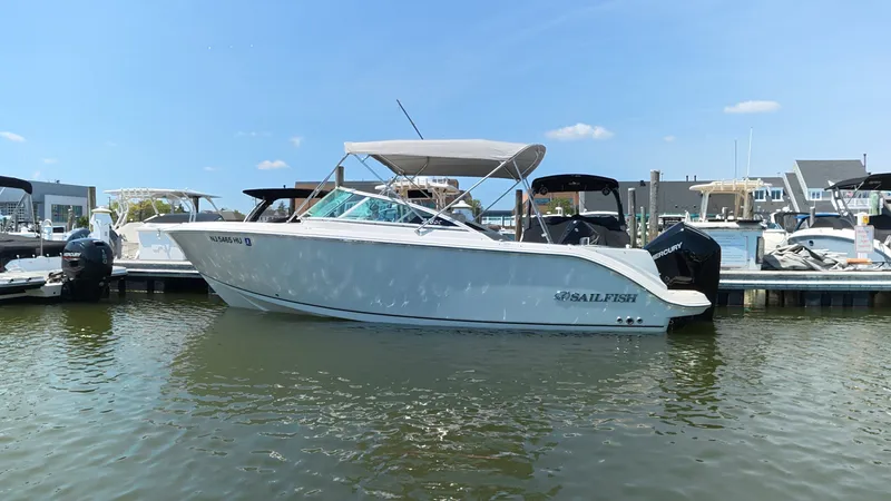 Slide: The Image of 2024 Sailfish 226 DC boat docked in marina on a sunny day. - 2