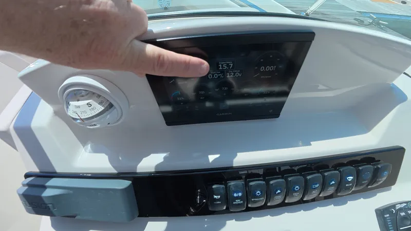 Slide: The Image of Hand pointing at dashboard of 2024 Sailfish 226 DC boat. - 23