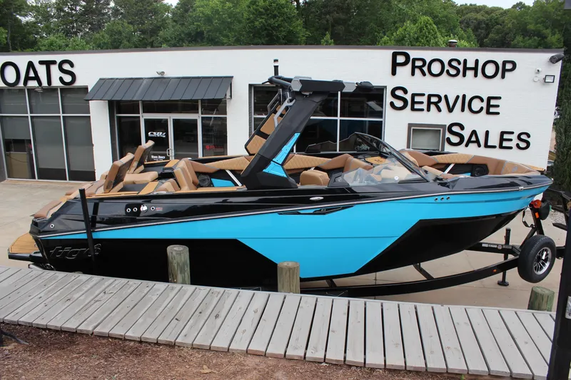 Slide: The Image of 2026 Tigé Z3 boat in blue and black, displayed at a pro shop. - 2