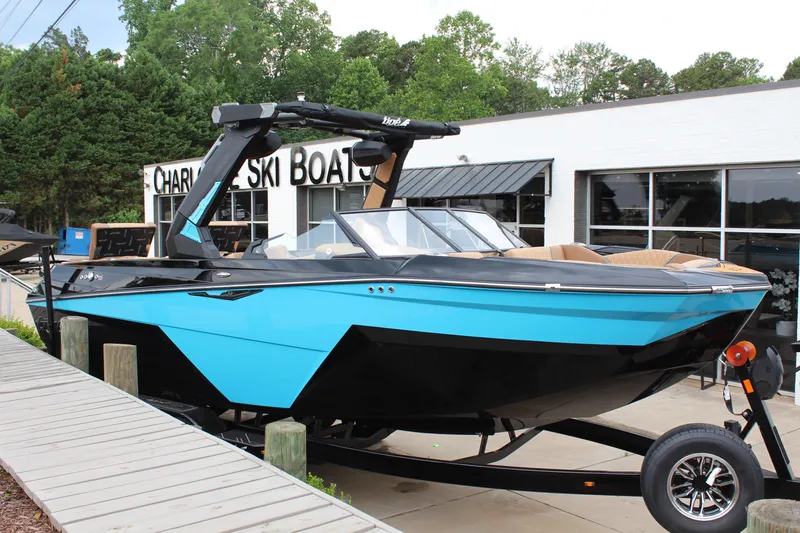 The Image of 2026 Tigé Z3 boat in blue and black, parked outside a ski boat dealership. - 1