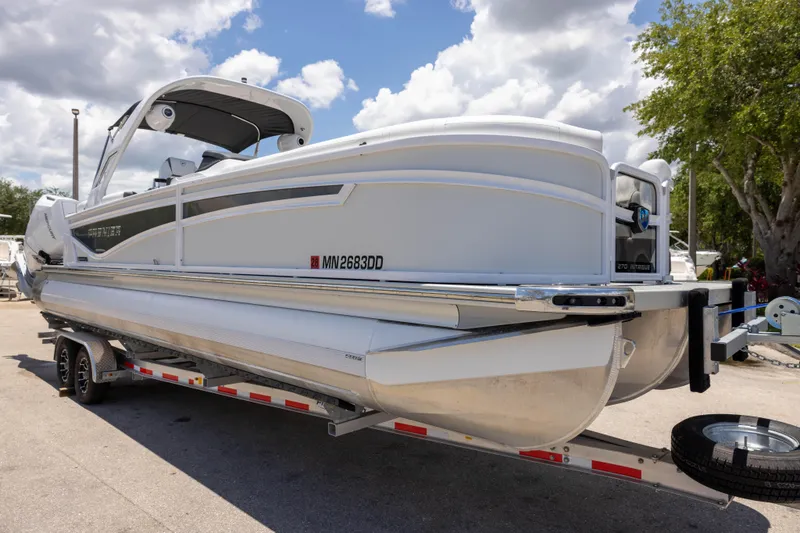 The Image of 2026 Premier 270 Intrigue RF - CL pontoon boat on trailer under cloudy sky. - 0