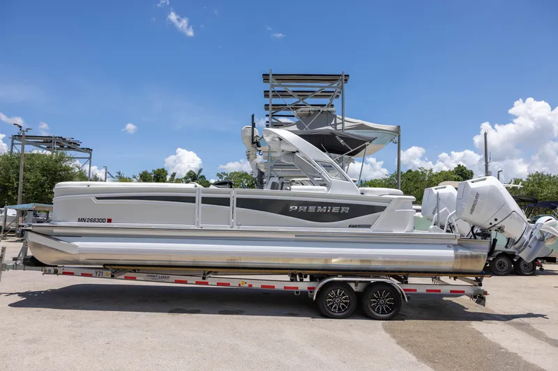 Slide: The Image of 2026 Premier 270 Intrigue RF - CL pontoon boat on trailer under clear blue sky. - 2