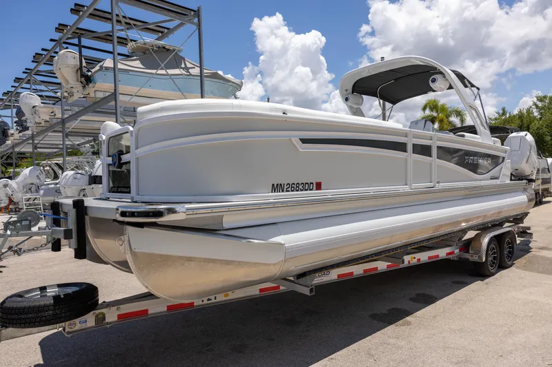 Slide: The Image of 2026 Premier 270 Intrigue RF - CL pontoon boat on trailer, sunny day, marina background. - 3