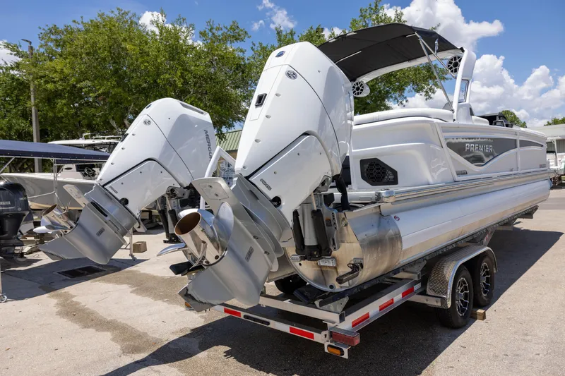 Slide: The Image of 2026 Premier 270 Intrigue RF - CL pontoon boat on trailer, featuring dual outboard motors. - 6