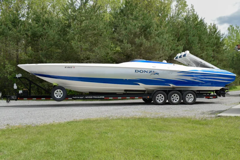 The Image of 2005 Donzi 38 ZR speedboat on trailer, featuring sleek blue and white design. - 0