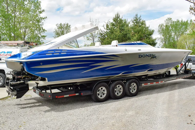 Slide: The Image of 2005 Donzi 38 ZR speedboat on trailer, featuring sleek blue and white design. - 1