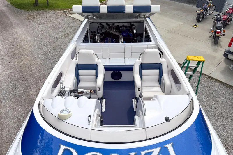 Slide: The Image of 2005 Donzi 38 ZR boat interior with blue and white seating, parked on concrete. - 24