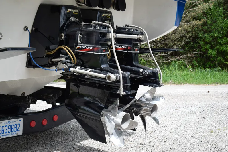 Slide: The Image of 2005 Donzi 38 ZR boat with dual Mercury Racing engines and propellers, parked on gravel. - 4