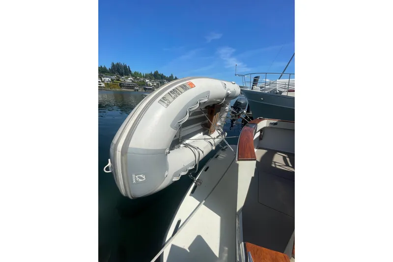 Slide: The Image of 1974 Tollycraft 37 Sedan with inflatable dinghy on calm water. - 10