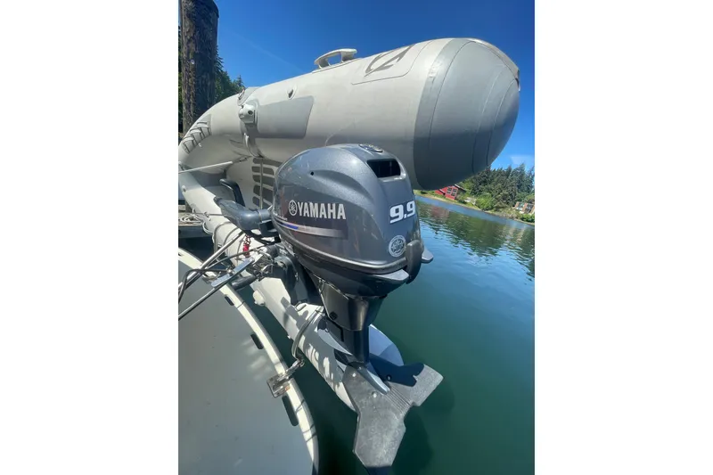 Slide: The Image of Yamaha 9.9 outboard motor on a Tollycraft 37 Sedan, 1974, docked by a scenic lake. - 12