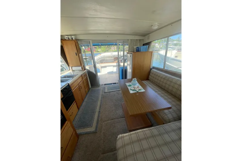 Slide: The Image of 1974 Tollycraft 37 Sedan interior with kitchen, dining area, and waterfront view. - 16