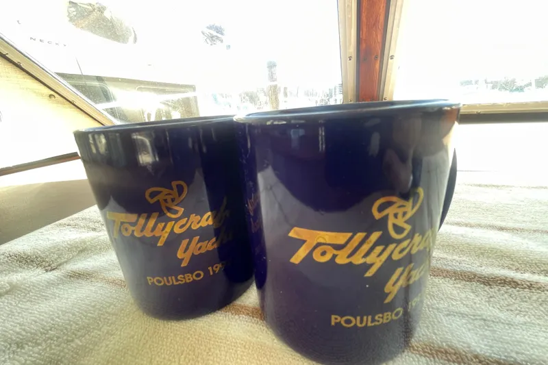 Slide: The Image of Two blue mugs with "Tollycraft Yachts Poulsbo 1974" logo on a boat. - 21