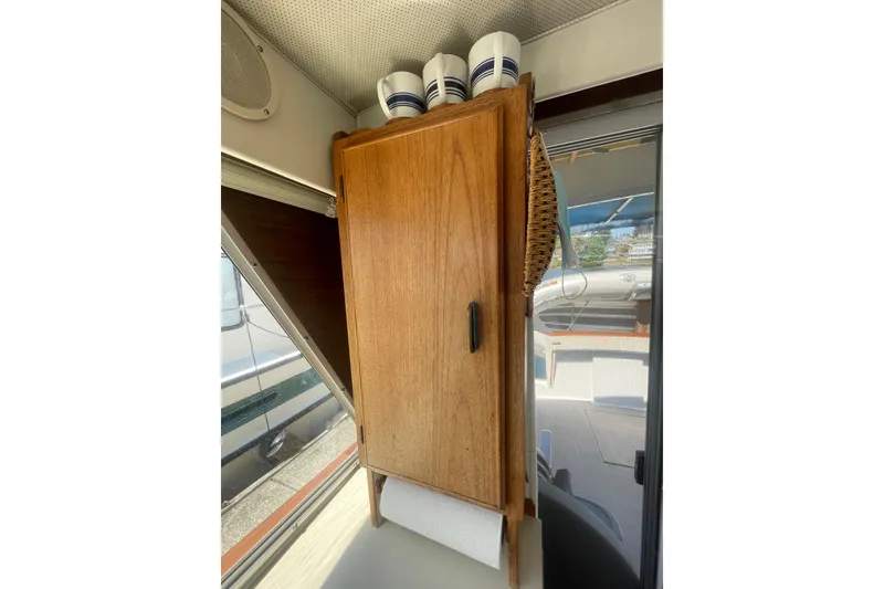 Slide: The Image of Wooden cabinet with cups and paper towel in 1974 Tollycraft 37 Sedan boat interior. - 22